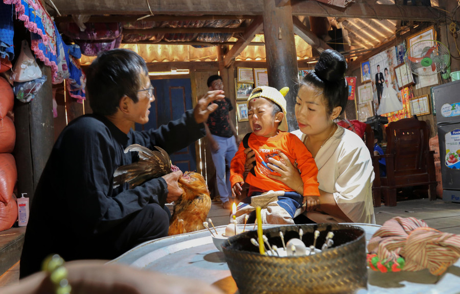 Thầy mo thực hiện nghi thức phết huyết gà lên trán, với ý nghĩa giải hạn, cầu phúc cho từng thành viên trong gia đình. Thầy mo thực hiện nghi thức phết huyết gà lên trán, với ý nghĩa giải hạn, cầu phúc cho từng thành viên trong gia đình.