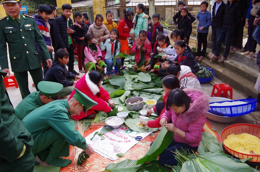 Chiến sĩ đồn BP Lũng Cú cùng bà con gói bánh chưng