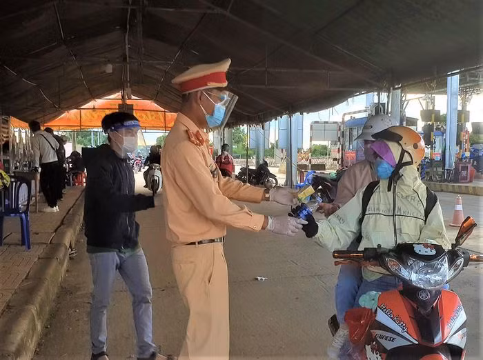 Thương những người dân chạy hàng trăm cây số về quê nhưng không có thời gian dừng lại nghỉ ngơi, nhiều tấm lòng thiện nguyện đã góp công, góp của nấu bánh bao, bánh ú, trái bắp (ngô luộc) nóng hổi, tiếp sức người đi đường. Trong ảnh: Người về từ các tỉnh phía nam được tặng nước uống, sữa... tại chốt Cai Chanh. Nguồn: TPO.