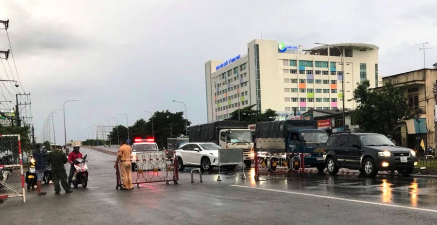 Lực lượng chức năng dừng, kiểm tra phương tiện lưu thông thực hiện phòng, chống dịch bệnh Covid-19 tại khu vực cầu Vĩnh Bình, TP.Thuận An. Ảnh: Báo Bình Dương.