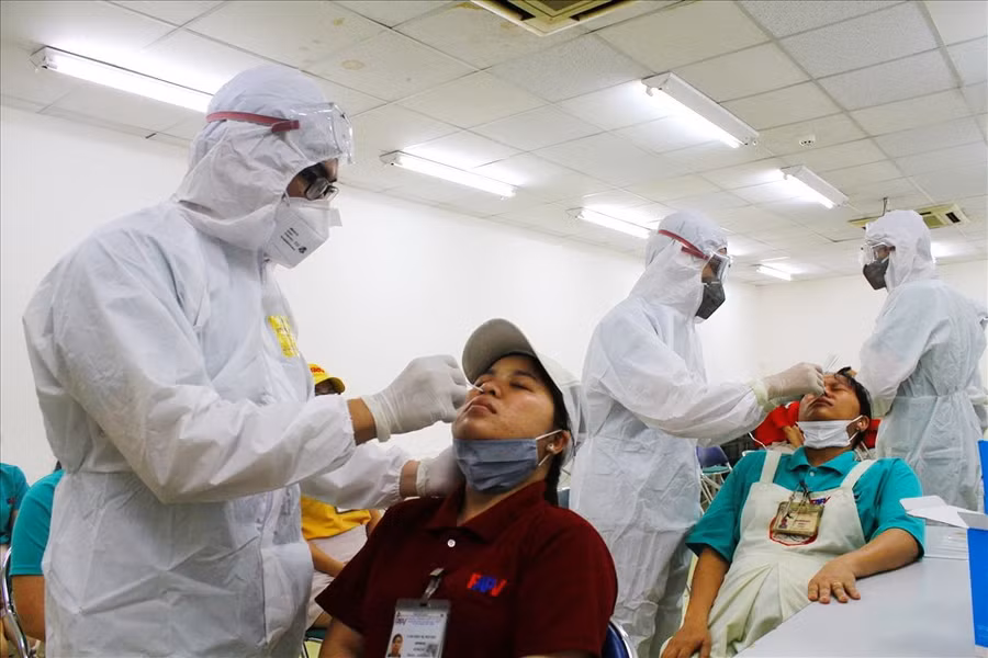 Nhân viện y tế lấy mẫu tầm soát Covid-19 cho công nhân. Ảnh minh họa.