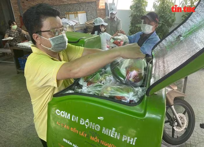 Xe "cơm di động miễn phí" đi khắp các nẻo đường phát cơm tận tay cho người nghèo là sáng kiến của anh Nguyễn Tuấn Khởi để nhằm hạn chế việc tụ tập đông người tại một điểm phát cơm. Nguồn: Báo Tin tức.