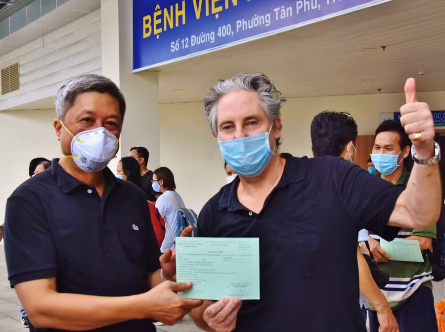 Thứ trưởng Bộ Y tế Nguyễn Trường Sơn trao giấy chứng nhận xuất viện cho ông Piers Birtwistle - một bệnh nhân ngoại quốc. Ảnh: BYT.