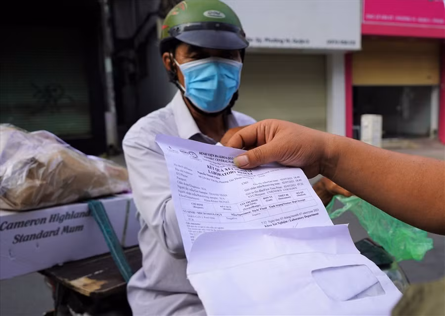 Cán bộ công an đang kiểm tra giấy tờ của người dân tại chốt trên đường Lê Văn Sĩ, Quận 3 trong chiều 9/7. Ảnh: LĐO.
