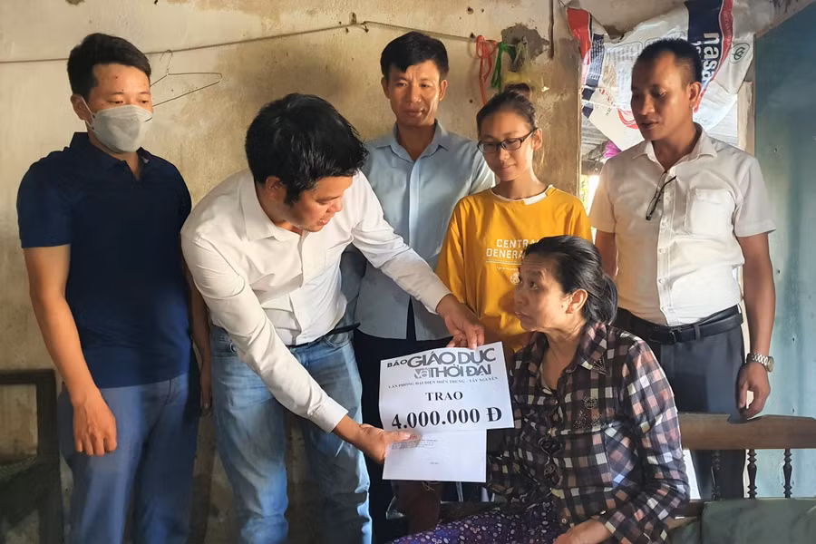 Đại diện Báo GD&TĐ khu vực Miền Trung - Tây Nguyên cùng lãnh đạo chính quyền địa phương trao quà bạn đọc đến mẹ con bà Ngoán.