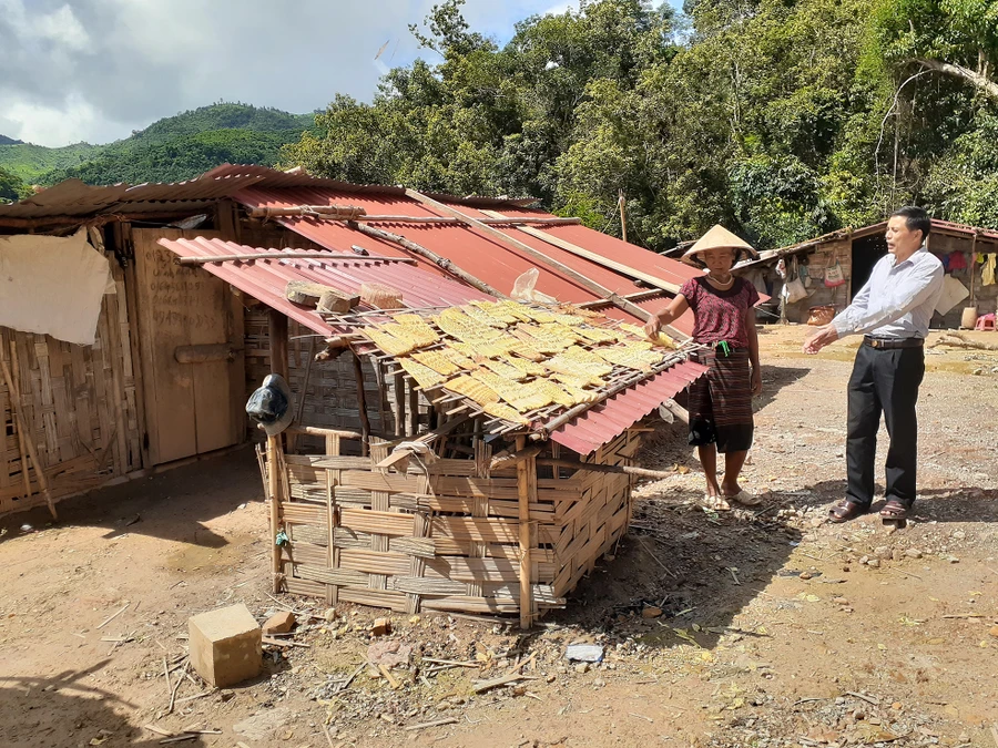 Ông Lò Văn Liên trao đổi với bà Nạ Thị Đăm (dân tộc Cống) bên căn nhà tạm bợ. Ảnh: TG