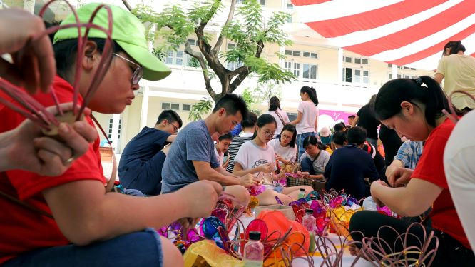Nhóm thiện nguyện Tim Hồng hướng dẫn thiếu nhi và trẻ khuyết tật cùng làm đèn cù.
