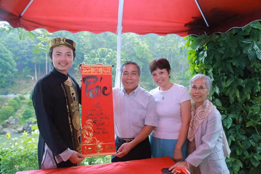 Nhà thư pháp Lê Dương Duyên cho chữ khách tham quan 