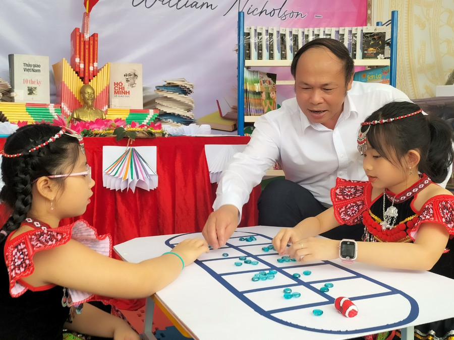 Ông Nguyễn Ngọc Quang, Phó giám đốc Sở GD&ĐT tỉnh Sơn La hướng dẫn học sinh trò chơi ô ăn quan. Ông Nguyễn Ngọc Quang, Phó giám đốc Sở GD&ĐT tỉnh Sơn La hướng dẫn học sinh trò chơi ô ăn quan.