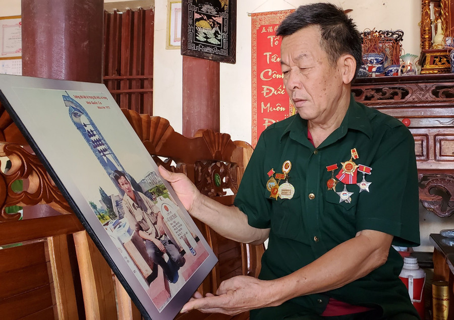 Ông Thành bên tấm ảnh ngày đầu tiên trở lại thăm chiến trường xưa.