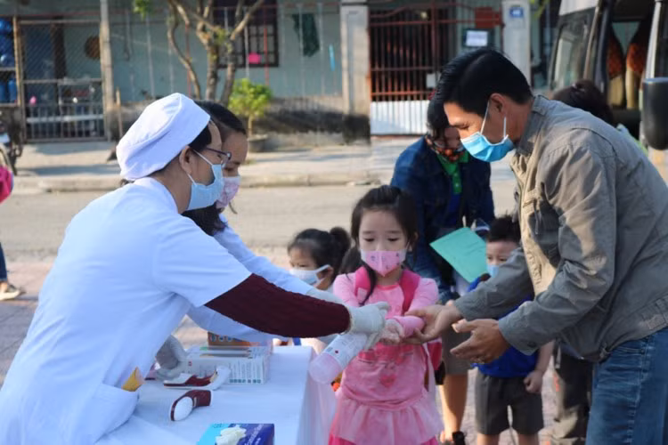 Nhân viên y tế rửa tay cho học sinh khi vào trường tại TP Huế. Ảnh: Minh Ngọc