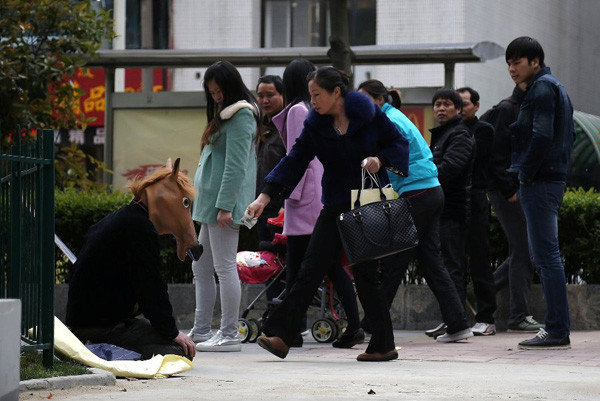 Bố làm "ngựa người" kiếm tiền chữa bệnh cho con ảnh 2 A female passer-by gives Chen some money on Shouchun Road in Hefei, capital city of East China