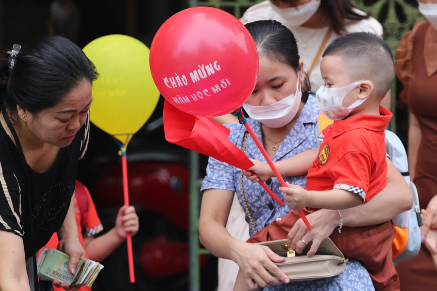 Nhiều cháu nhỏ được bố mẹ mua bóng bay, cờ để dự lễ khai giảng năm học mới.