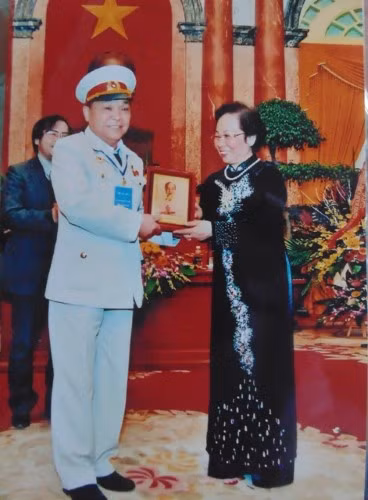 Nguyên Phó Chủ tịch nước Nguyễn Thị Doan trao kỉ vật cho cựu chiến binh Ngô Xuân Tự trong cuộc gặp mặt những người có công.