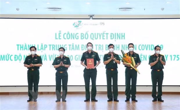 Trung tướng Ngô Minh Tiến trao Quyết định thành lập Trung tâm điều trị bệnh nhân Covid-19 mức độ nặng và vừa thuộc Bệnh viện Quân y 175. Ảnh: TTXVN.