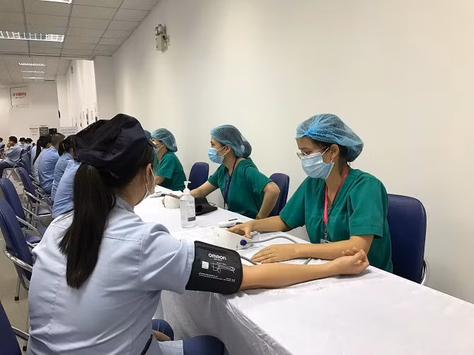 Cán bộ, công nhân tại nhiều doanh nghiệp trên địa bàn huyện Mê Linh được khám sáng lọc, tiêm vắc xin phòng bệnh. Nguồn: Sở Y tế Hà Nội.