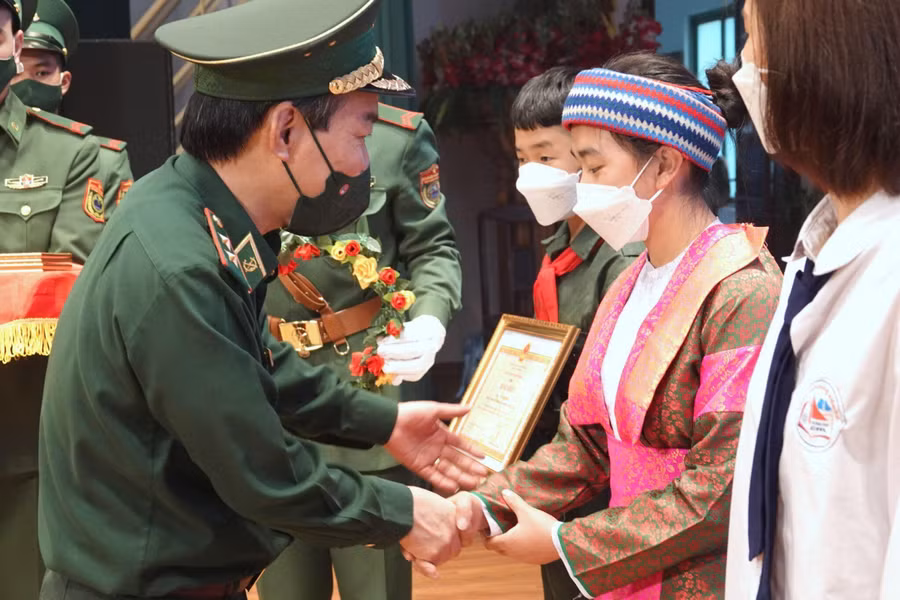 Trung tướng Đỗ Danh Vượng, Chính ủy BĐBP tặng Bằng khen cho các em học sinh con nuôi Đồn biên phòng.