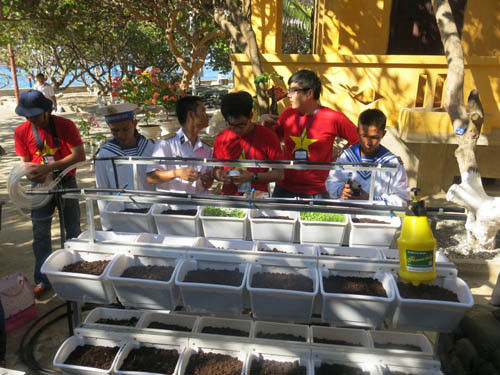Các thành viên đang hướng dẫn chiến sĩ trên đảo Phan Vinh sử dụng giàn rau tưới tự động. Ảnh: VA 5-nguoi-viet-o-han-quoc-dua-may-phat-dien-toi-truong-sa-1