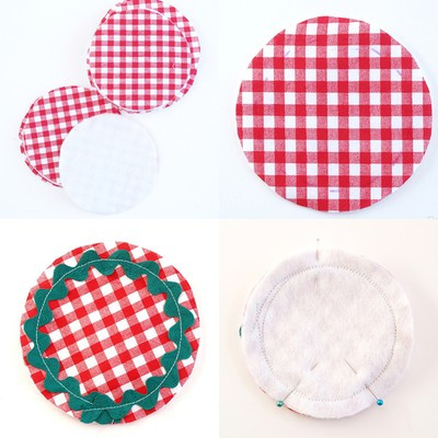 Cắt vải cotton carô đỏ thành 2 tấm hình tròn có đường kính 12cm. Cắt vải nỉ trắng thành 1 tấm hình tròn có đường kính 12cm. Đặt chồng 1 tấm hình tròn carô đỏ lên trên tấm hình tròn màu trắng, vẽ vòng tròn có đường kính 10cm lên mặt tấm vải carô đỏ. Khâu dây đăng-ten theo vòng tròn đã vẽ trên tấm vải carô đỏ và vải nỉ trắng. Úp mặt phải của tấm vải vừa khâu dây đăng-ten lên trên mặt phải của tấm vải carô đỏ còn lại, ghim ổn định. Cắt vải cotton carô đỏ thành 2 tấm hình tròn có đường kính 12cm. Cắt vải nỉ trắng thành 1 tấm hình tròn có đường kính 12cm. Đặt chồng 1 tấm hình tròn carô đỏ lên trên tấm hình tròn màu trắng, vẽ vòng tròn có đường kính 10cm lên mặt tấm vải carô đỏ. Khâu dây đăng-ten theo vòng tròn đã vẽ trên tấm vải carô đỏ và vải nỉ trắng. Úp mặt phải của tấm vải vừa khâu dây đăng-ten lên trên mặt phải của tấm vải carô đỏ còn lại, ghim ổn định.