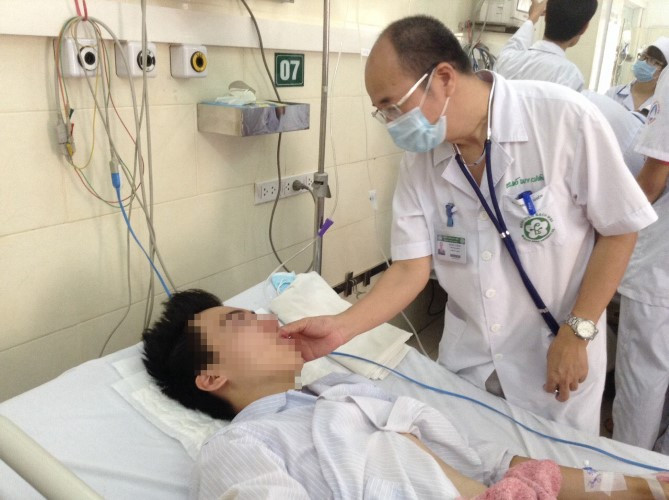 PGS.TS Đỗ Duy Cường thăm khám cho bệnh nhân mắc sốt xuất huyết. Ảnh: BVCC.