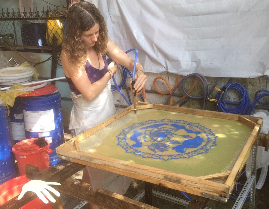 Du khách nước ngoài trải nghiệm cách vẽ tranh bằng giấy dừa tại xưởng của anh Hà.