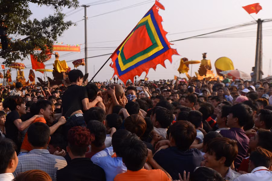 16h chiều, bô lão là những người thủ cầu bắt đầu tung quả phết ra trước cổng đình, ngay lập tức hàng trăm thanh niên xông vào cướp.