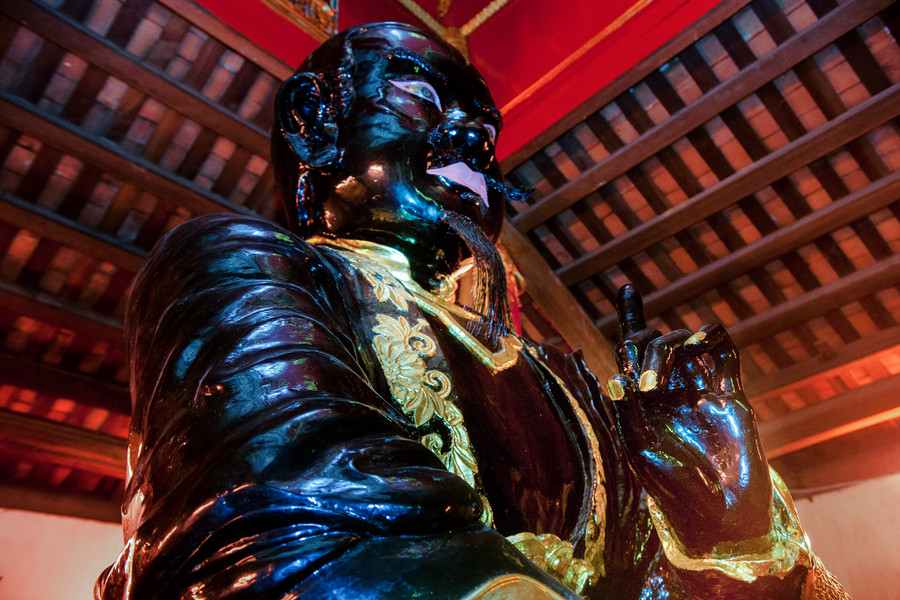 Bức tượng có dáng ngồi khoan thai, tay trái bắt quyết.