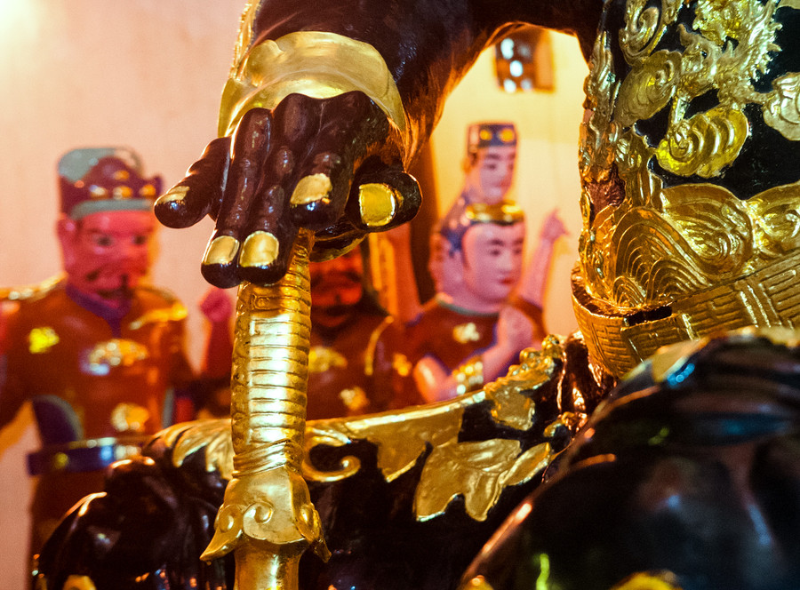 Tay phải tướng úp trên đốc kiếm. Thanh kiếm có rắn quấn quanh được chống trên lưng rùa. Đây cũng là nét đăc trưng của các bức tượng Huyền Thiên Trấn Vũ.