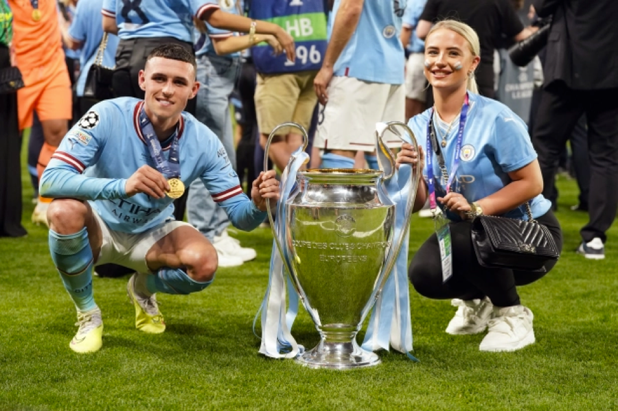 Phil Foden và bạn gái Rebecca Cooke chụp ảnh bên chiếc cúp vô địch. Phil Foden và bạn gái Rebecca Cooke chụp ảnh bên chiếc cúp vô địch.