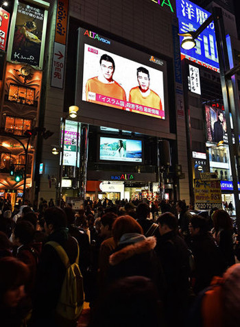 Người đi đường Nhật Bản theo dõi vụ bắt cóc hai con tin trên một màn hình lớn ở Tokyo. Ảnh: AP Người đi đường Nhật Bản theo dõi thông tin về vụ bắt cóc hai con tin trên một màn hình lớn ở Tokyo. Ảnh: AP