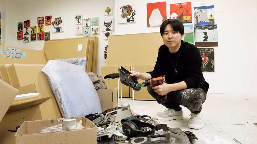 Nghệ sĩ Nagasaka Mago bên rác điện tử nhặt từ Ghana về Nhật Bản. Ảnh: Yoshii Taeko, Nippon.com