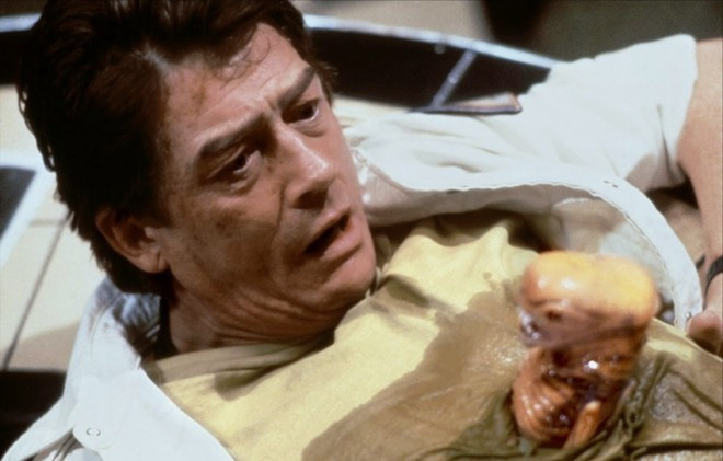 Alien (1979): Loài quái vật không gian không chỉ khiến người xem khiếp đảm với tạo hình khi trưởng thành mà còn gieo rắc nỗi sợ hãi với hình ảnh thuở sơ sinh, khi chúng còn nằm trong những quả trứng nhớp nhúa. Nó có chiếc đuôi dài nhằm cấy trứng ký sinh vào cơ thể sống khác. Hình ảnh con quái vật tí hon ngóc đầu ra ngọ nguậy giữa lồng ngực nhân vật Kane (William Hurt) chính là một trong những cảnh phim ghê rợn nhất lịch sử điện ảnh. 10 phim kinh dị lấy đề tài ký sinh trùng