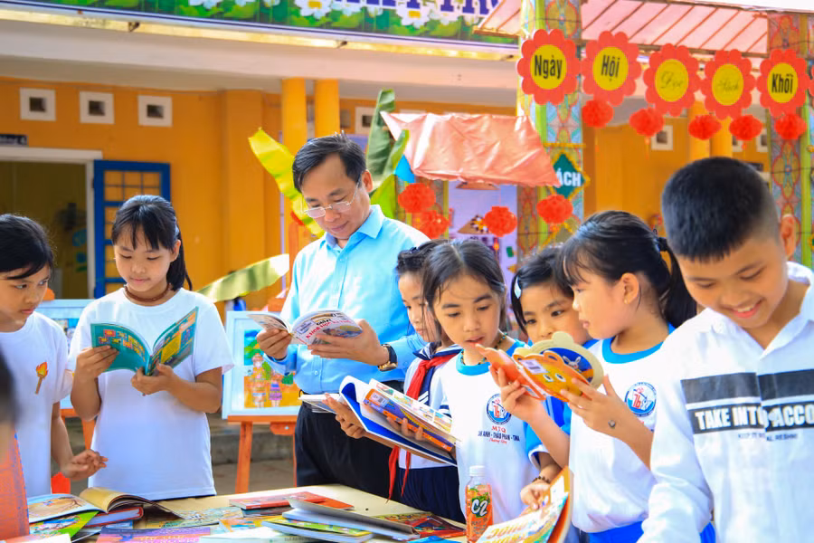 Thầy Dương Hồng Thắng - Hiệu trưởng nhà trường cùng đọc sách với các em học sinh.