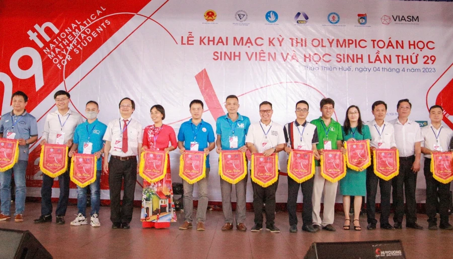 Tặng cờ lưu niệm cho các đơn vị tham dự Kỳ thi Olympic Toán học sinh viên và học sinh lần thứ 29. (Ảnh: Hoàng Hải).