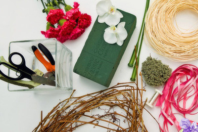 - Hoa để cắm: hoa cẩm chướng hồng 30 bông, hoa lan trắng 2 bông - Cây dây leo khô có thể uốn cong thành nhiều vòng tròn - Bình cắm hoa vuông, cao 10-15cm - Dây trang trí: dây ruy-băng hồng, dây mây nhỏ (có thể dùng dây giấy cùng màu) - Rêu khô, kẽm nhỏ - Hạt cườm màu hồng đậm, nhạt - Dụng cụ: xốp cắm hoa, ống hoa 2 chiếc, kéo cắt cành hoa - Hoa để cắm: hoa cẩm chướng hồng 30 bông, hoa lan trắng 2 bông - Cây dây leo khô có thể uốn cong thành nhiều vòng tròn - Bình cắm hoa vuông, cao 10-15cm - Dây trang trí: dây ruy-băng hồng, dây mây nhỏ (có thể dùng dây giấy cùng màu) - Rêu khô, kẽm nhỏ - Hạt cườm màu hồng đậm, nhạt - Dụng cụ: xốp cắm hoa, ống hoa 2 chiếc, kéo cắt cành hoa