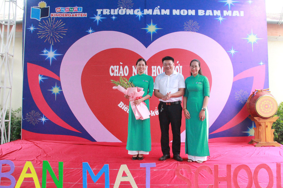 Đại diện hội phụ huynh tặng hoa chúc mừng nhà trường. (Ảnh: Vũ Long)