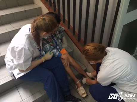 Nu sinh Dan Mach xinh dep quy xuong nang niu benh nhan nhi o Bach Mai - Anh 2