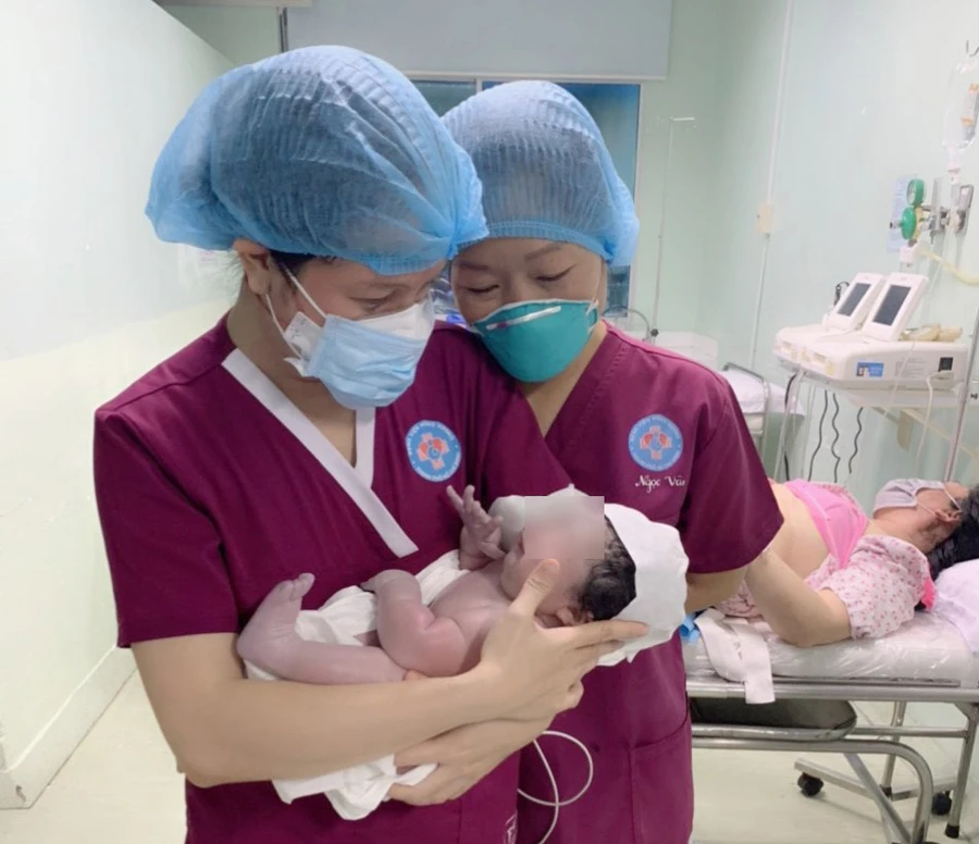 Các y bác sĩ bất ngờ bé trai nặng hơn 5,1 kg được sinh thường thành công. Ảnh: Báo Tin tức.