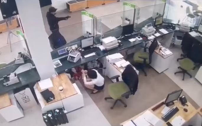 Nam thanh niên rút vật giống súng đe dọa nhân viên ngân hàng. Ảnh: Internet.