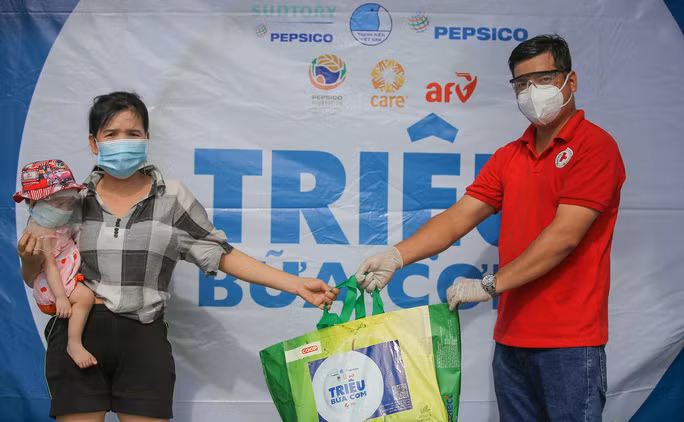 Ban quản lý Chương trình Hỗ trợ Phát triển quận Bình Tân, TP Hồ Chí Minh vừa triển khai hoạt động hỗ trợ khẩn cấp cho công nhân, người lao động khó khăn do ảnh hưởng của dịch bệnh Covid-19 trên địa bàn quận. Hoạt động nằm trong Dự án “Triệu bữa cơm 2021”. Trong ảnh: Trao quà cho công nhân có hoàn cảnh khó khăn tại phường Bình Hưng Hòa. Nguồn: NLĐ.