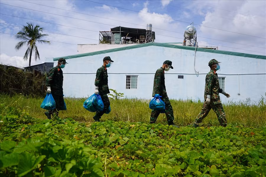 Lực lượng quân đội đi trao những phần quà, thực phẩm thiết yếu cho người dân với phương châm "đi từng ngõ, gõ từng nhà" để phát lương thực tận tay người dân. Nguồn: LĐO.