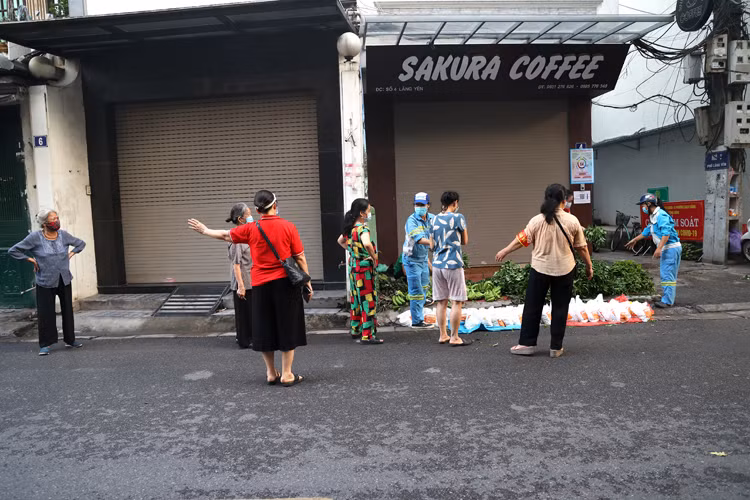 Mọi người đến nhận rau xếp hàng trật tự, đảm bảo giãn cách. Ảnh: Báo Tin Tức.