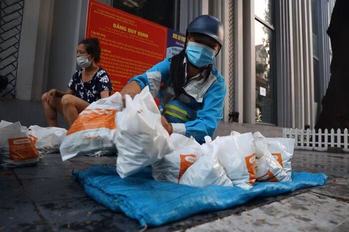 Khoảng 5h30 mỗi sáng, các chị lại tất bật bày sạp rau, quả miễn phí trên một góc phố của Thủ đô. Ảnh: Saostar.