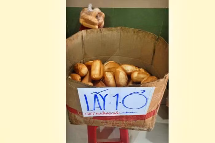 Thùng bánh mì đặt tại chung cư Bàu Cát 2, quận Tân Bình, phía trên có mảnh giấy ghi mấy chữ "Lấy 1 ổ. Giữ khoảng cách. Cảm ơn!". Ảnh: PLO.