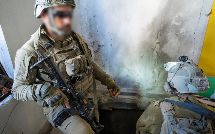 Một sĩ quan kỹ thuật chiến đấu chỉ một đường hầm mà họ tìm thấy bên trong một ngôi nhà ở phía bắc Gaza, ngày 7/11/2023 Một sĩ quan kỹ thuật chiến đấu chỉ một đường hầm mà họ tìm thấy bên trong một ngôi nhà ở phía bắc Gaza, ngày 7/11/2023