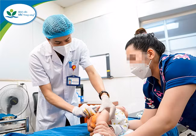 Bệnh nhi đang được bác sĩ Hoàng chăm sóc vết thương sau phẫu thuật. Nguồn: BV Nhi Trung ương.
