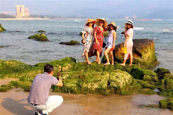 Du khách chụp ảnh lưu niệm tại bãi rêu Nam Ô. Ảnh: TG.