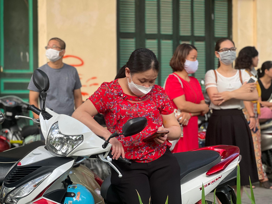 Vị phụ huynh này tham khảo các thông tin bên lề cuộc thi trong lúc chờ con.