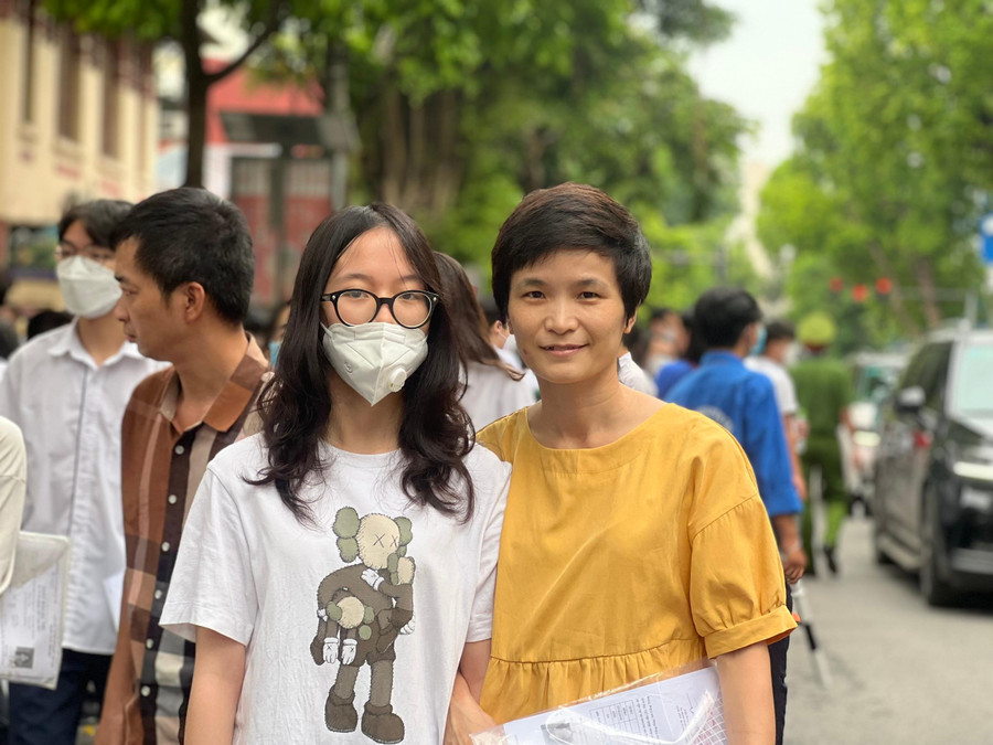 Mẹ cười rạng rỡ, khoác tay đón con bước ra từ cổng trường thi.