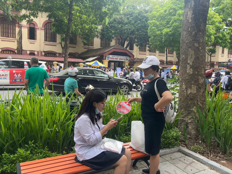 Mẹ quạt mát cho con trong lúc cô bé đang tra cứu thông tin về đề thi...Co